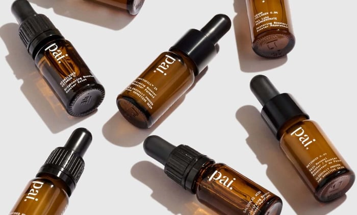 Pai Retinoid 0.3% vitamin A booster bottles arranged on white surface with dramatic shadows