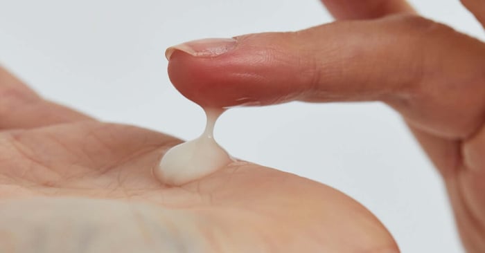Hands applying white moisturising cream to support healthy skin barrier function