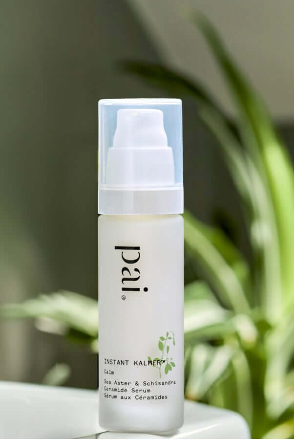 Pai Instant Kalmer ceramide serum with white pump dispenser against green foliage background