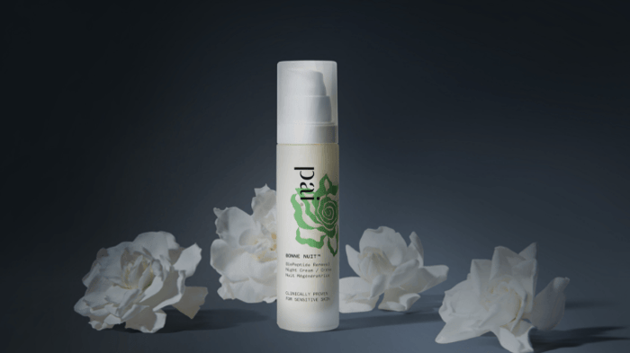 Bonne Nuit Balancing Night Cream surrounded by white roses on dark background