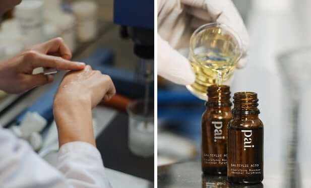 Lab technician applying Pai skincare booster oil to hand while amber glass bottles with droppers sit on laboratory counter
