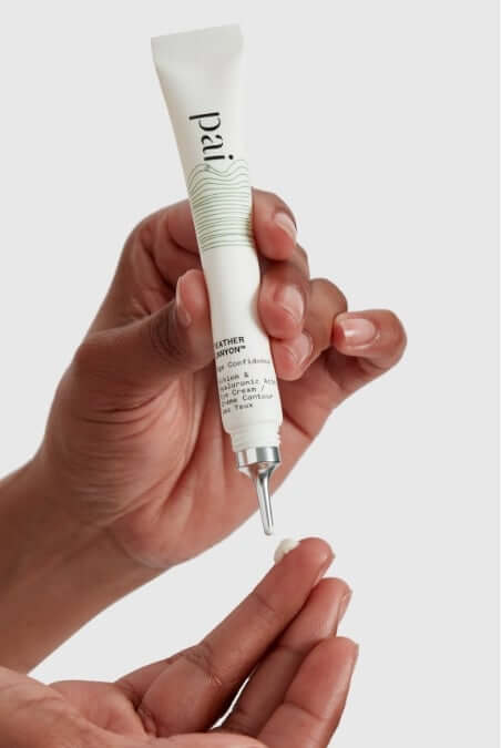 Hand dispensing Feather Canyon eye cream from white tube with green stripe detailing onto palm