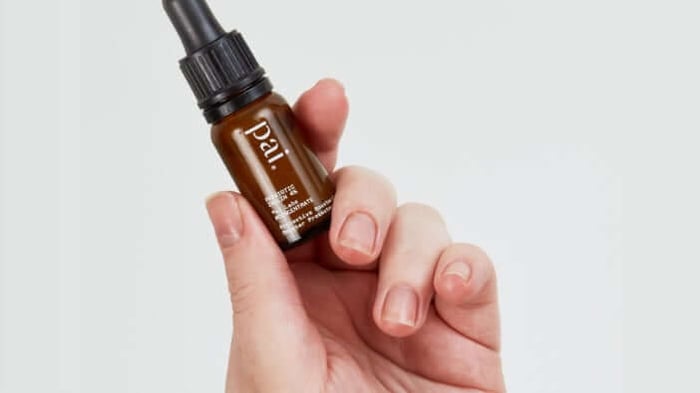 Hand holding Pai Skincare Prebiotic Inulin 4% Protective Booster against clean white background