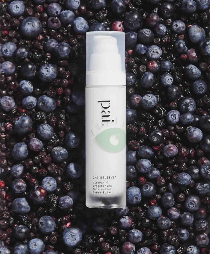 C-2 Believe Vitamin C Brightening Moisturizer surrounded by fresh blueberries and blackberries
