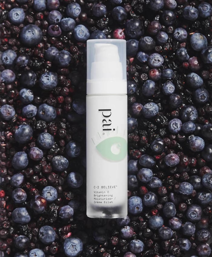 C-2 Believe Vitamin C moisturizer pump bottle surrounded by fresh blueberries and blackberries