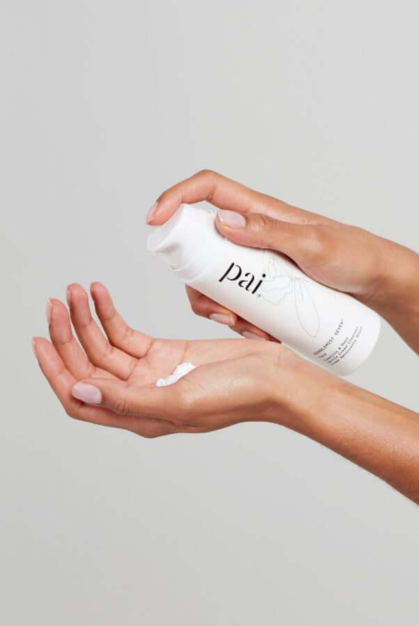 Hands dispensing Middlemist Seven cream cleanser into palm against neutral background