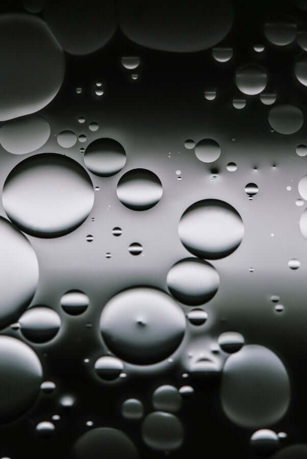 Abstract oil and water droplets creating bubble texture, representing skincare emulsions and oil cleansing benefits