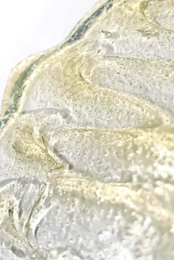 Close-up of gentle gel exfoliator texture with microscopic granules and hydrating bubbles for sensitive skin