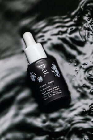 Carbon Star overnight treatment oil with dropper bottle on reflective water surface