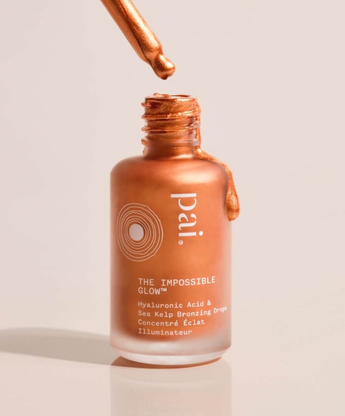 Pai Skincare The Impossible Glow bronzing serum with hyaluronic acid dripping from dropper