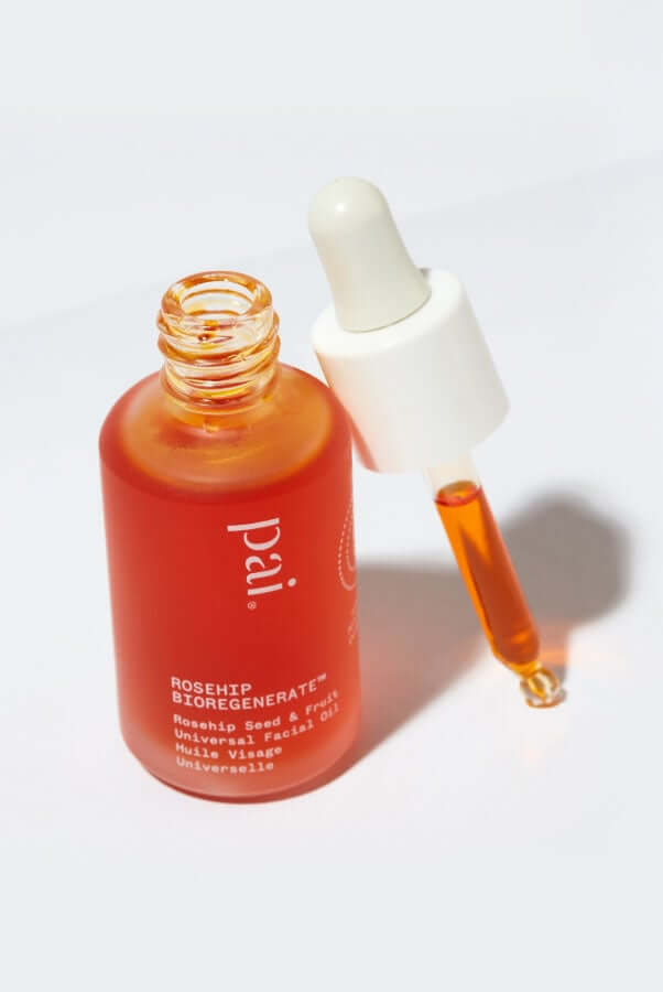 Pai Rosehip BioRegenerate Oil bottle with dropper dispensing golden oil, showing natural amber color