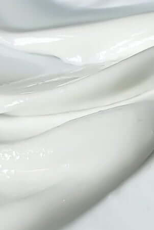 Gentle white moisturizer texture being applied, ideal for sensitive skin during chemotherapy treatment