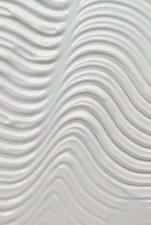 Smooth white cream texture with flowing wave patterns showing the luxurious consistency of facial moisturizer