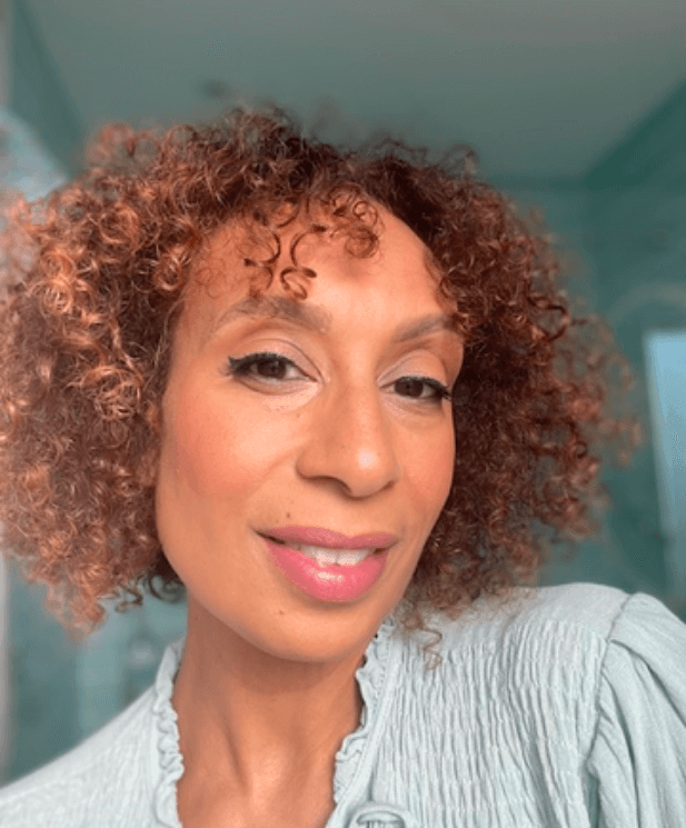 Anna Durston, makeup artist with curly hair, showcasing healthy glowing skin during menopause