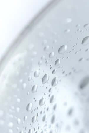 Close-up of water droplets forming on smooth skin surface showing glycerin's hydrating properties
