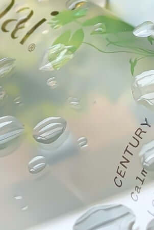 Century Flower Soothing Tonic with botanical extracts and water droplets on clear glass surface