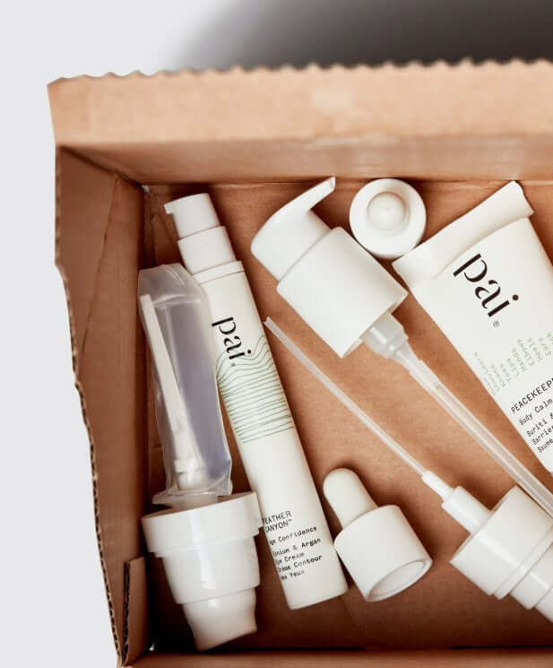 Pai Skincare products and tubes arranged in recycled cardboard packaging box showing sustainable beauty packaging