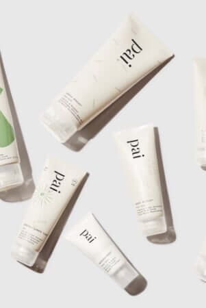 Pai Skincare organic certified tubes arranged in elegant flatlay showing sustainable packaging