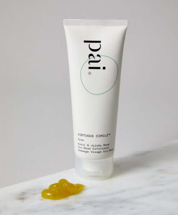 Pai Virtuous Circle Exfoliant tube with golden eco bead texture on marble surface