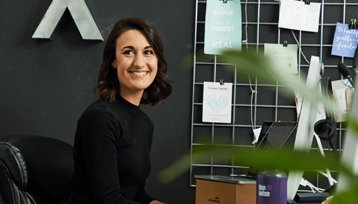 Sarah Brown, Pai Skincare founder, smiling in her London office surrounded by product development notes and mood boards