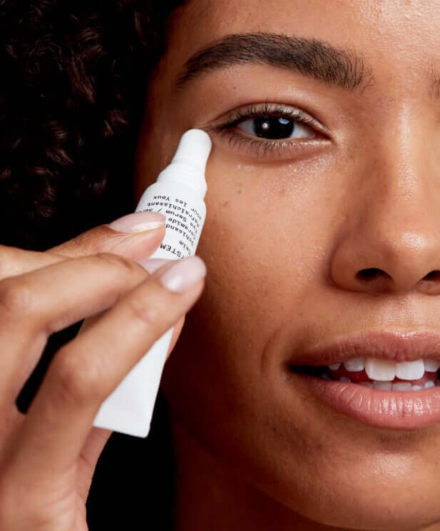 Model applying Pai Echium & Argan Eye Cream with ceramic applicator near the under-eye area