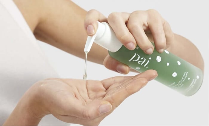 Hands dispensing Pai Skincare Phaze PHA gentle exfoliating cleanser onto palm, showing clear gel texture