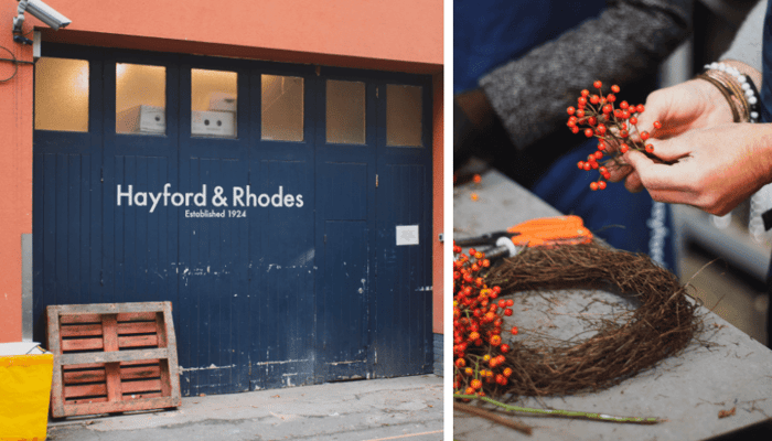 Hands adding bright orange rosehips to a rustic twig wreath base during Christmas craft making
