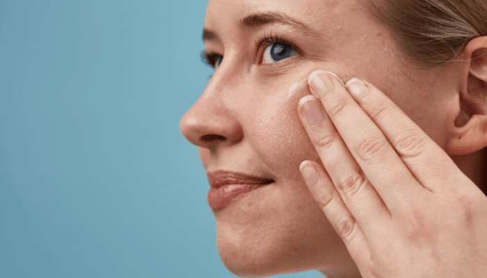 Woman applying Copaiba & Zinc Perfect Balance Blemish Serum to face with gentle pressing motion