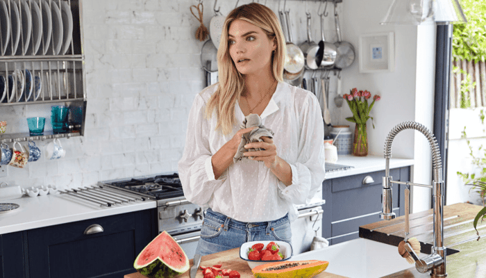 Nutritional therapist Frances Phillips in modern kitchen preparing fresh fruit smoothie with strawberries and watermelon
