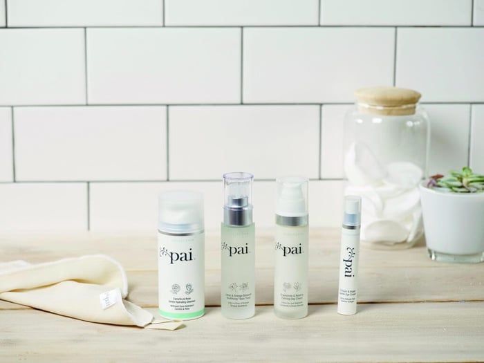 Four Pai Skincare products arranged on bathroom counter with white subway tile wall - cleanser, toner, moisturizer and eye cream for sensitive skin routine