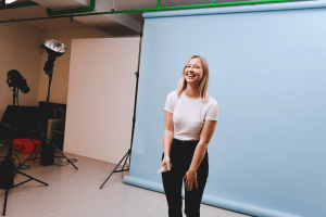 Behind the scenes photo shoot with Pai team member Emily posing naturally in pink top against white backdrop