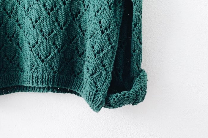 Soft green knitted cotton sweater showing natural fabric texture for sensitive skin comfort