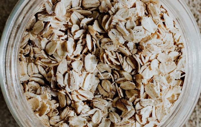 Bowl of rolled oats flakes showing potential dietary triggers for hand eczema