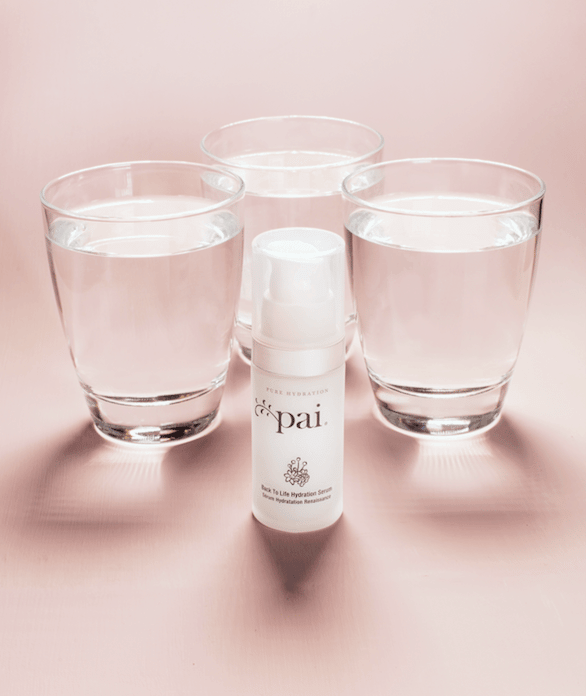 Back to Life Hydration Serum bottle surrounded by three glasses of water on soft pink background