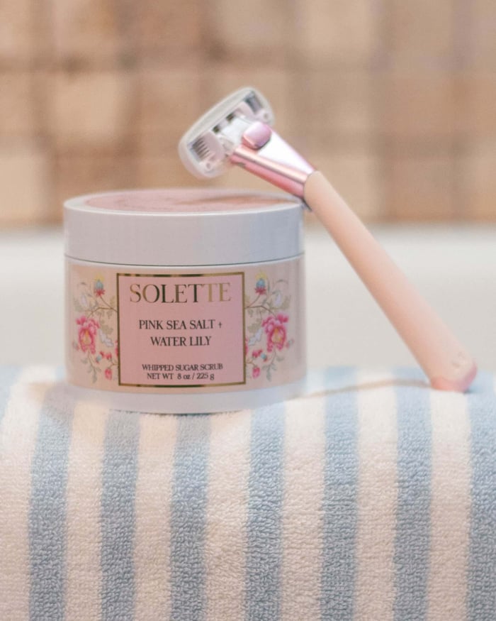 pink sea salt body scrub with a pink razor