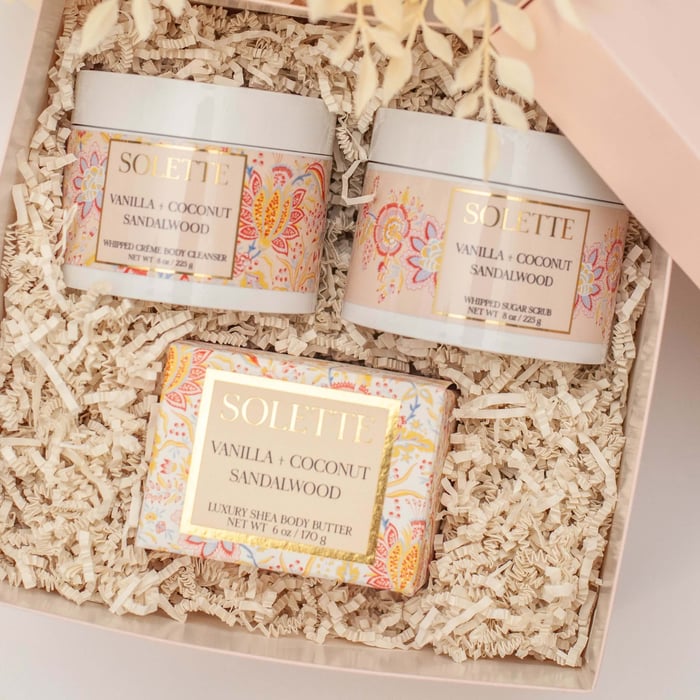 box filled with body butters, body scrubs, and body washes