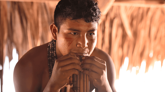 One of the native musicians performing a pan flute-like instrument