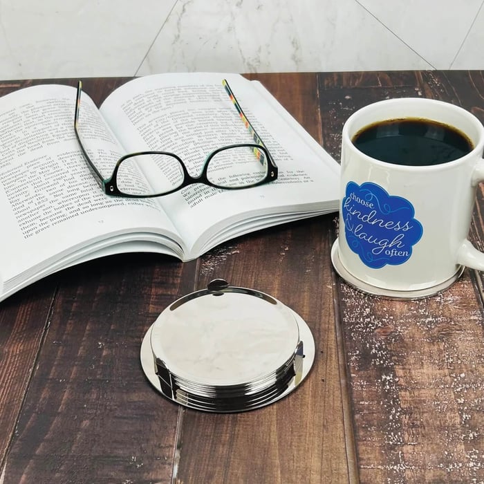 A coffee mug on custom engraved silver coasters