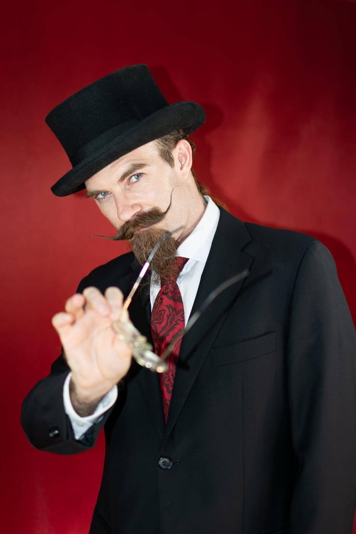 A man dressed in a costume to be the villain at a mystery party