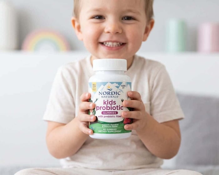 Probiotyk dla dzieci w żelkach: dziecko trzyma Kids Nordic Flora Probiotic Gummies Nordic Naturals