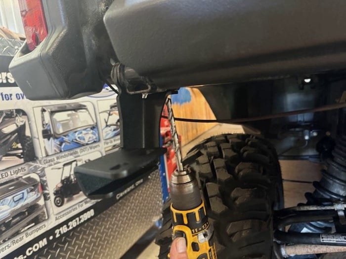 Drilling the 1/4 inch hole through the frame tube on a Honda Pioneer 1000-6