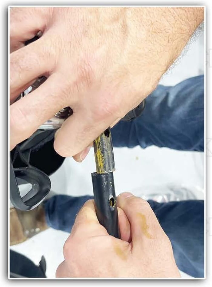 Hands flexing the lower door frame to line up the tubes