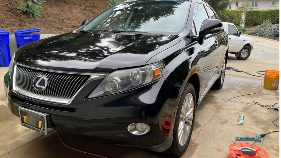 Black Lexus RX hybrid with glossy waxed finish in San Diego driveway