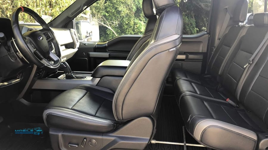 The deep-cleaned interior of a Ford F-150 in San Diego, highlighting professional truck detailing techniques on the leather seats and floor mats.