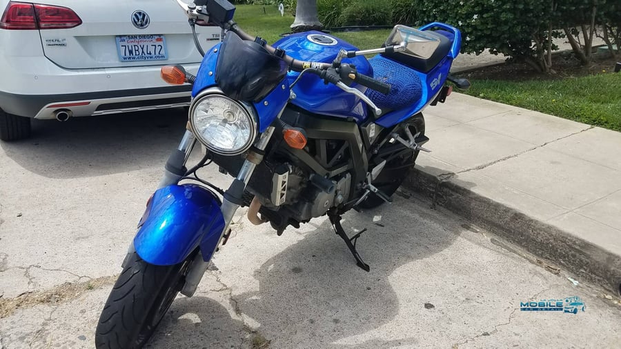 A blue Suzuki being serviced for motorcycle detailing in San Diego, illustrating the impact of coastal salt air on naked bike components.