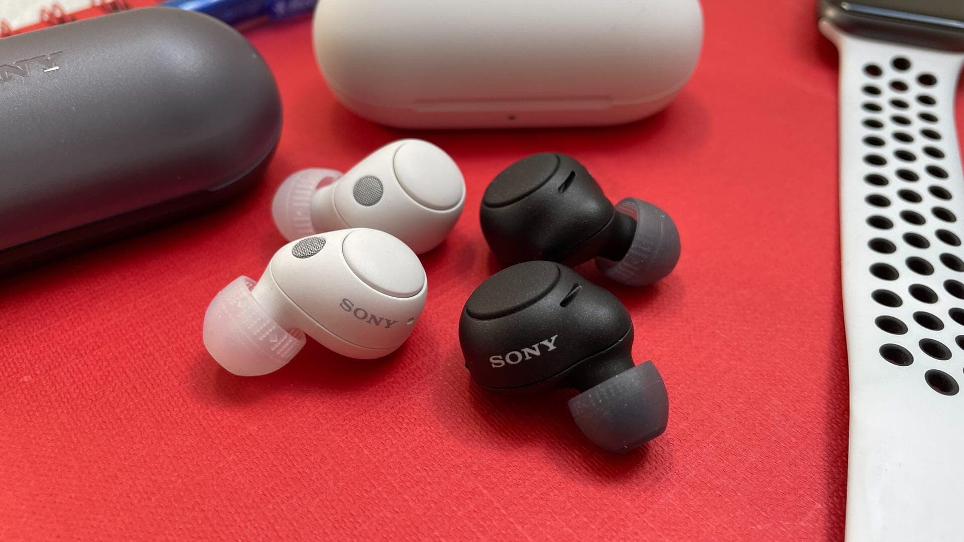 Sony WF-C700N earbuds and case on a wooden surface