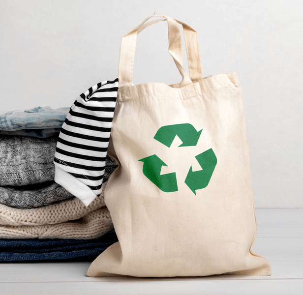 Canvas bag next to a stack of sweaters
