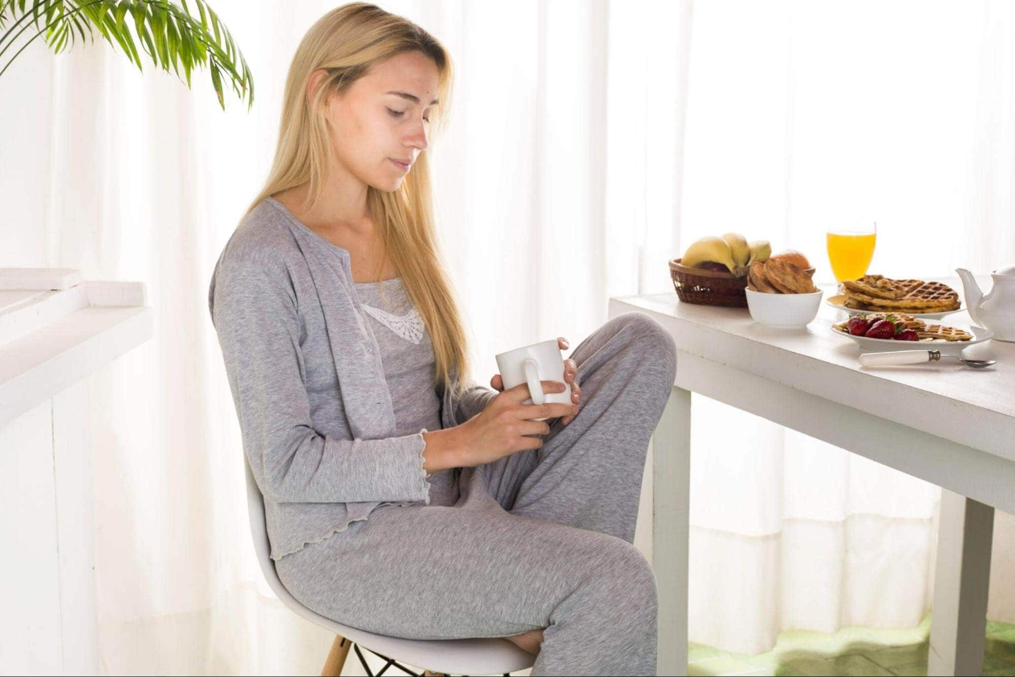 nervous woman sitting and holding coffee mug