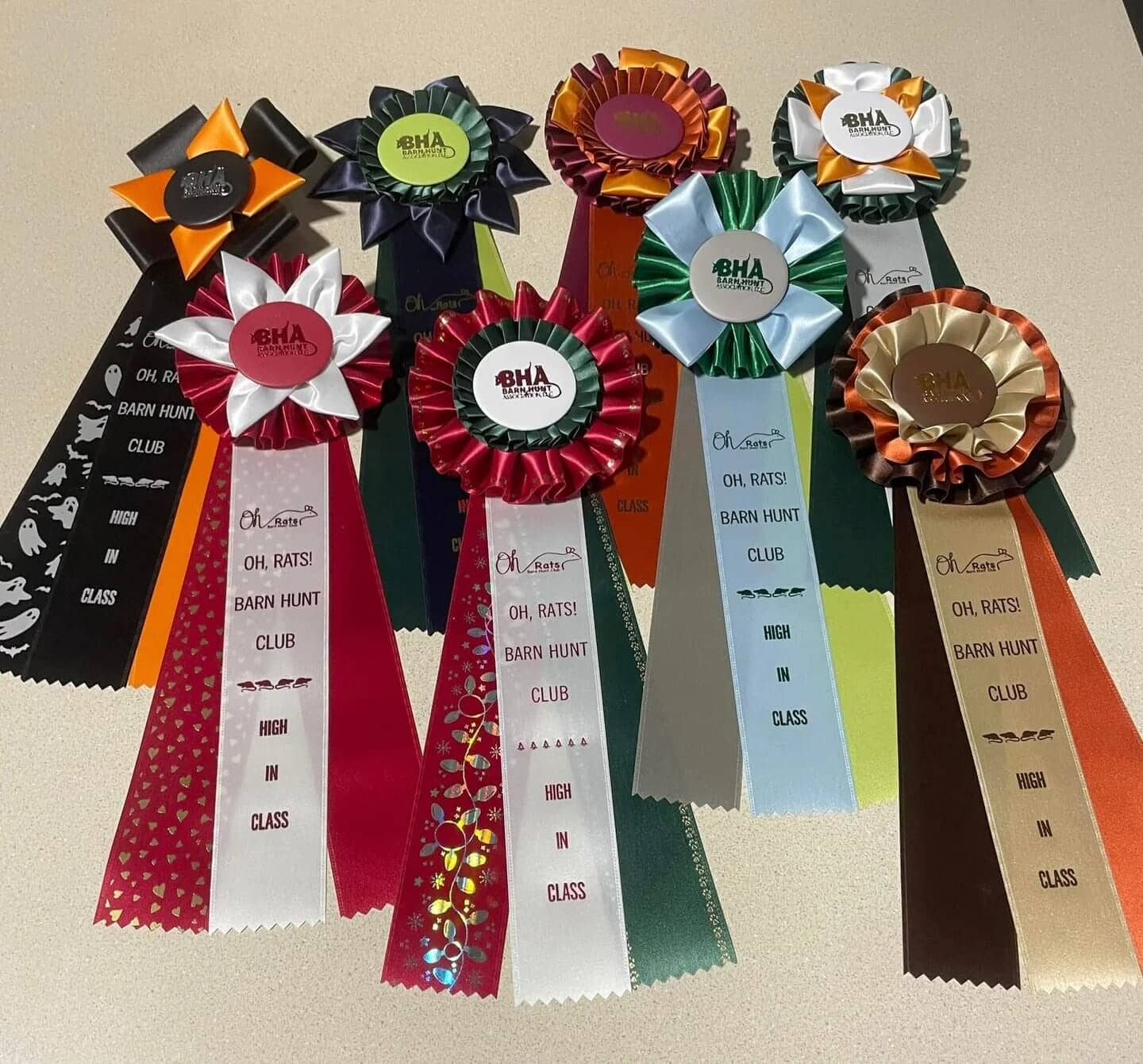 Custom rosette dog show awards from Oh Rats Barn Hunt Club with eye-catching ribbon designs.