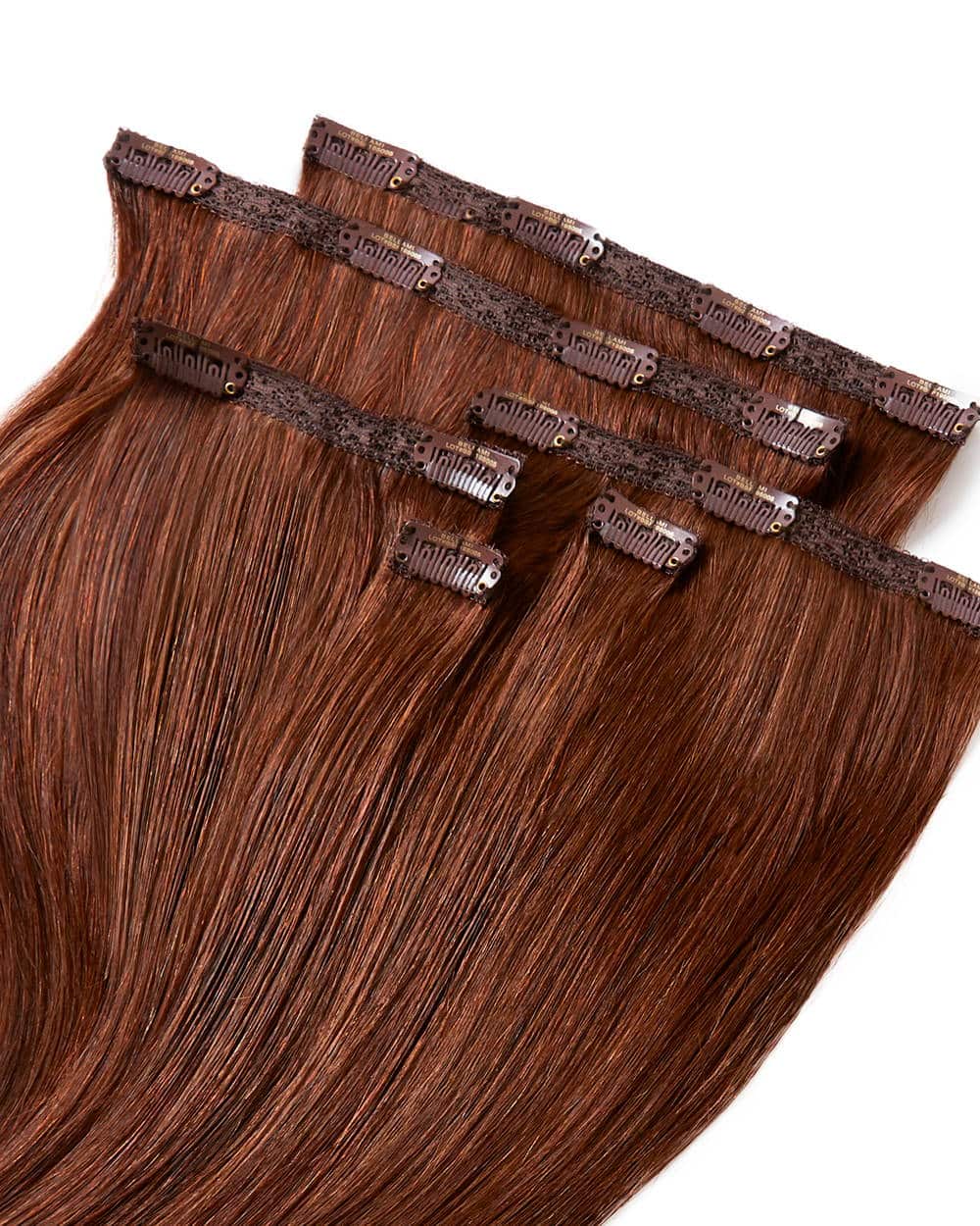 Close-up of brown clip-in hair extensions arranged in layers.
